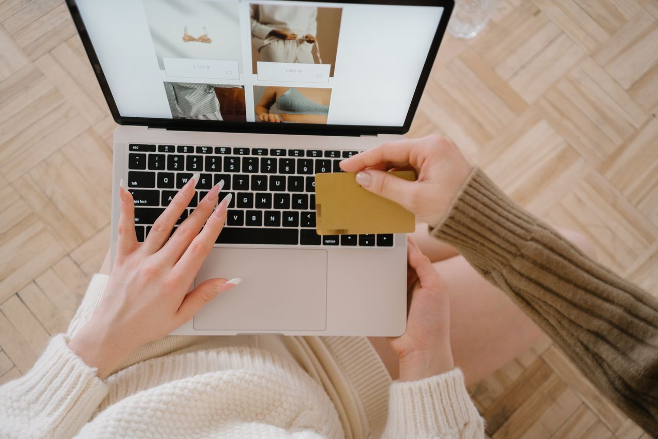 Osoba nakupujúca online pomocou notebooku a kreditnej karty, čím sa zdôrazňuje pohodlie e-commerce.