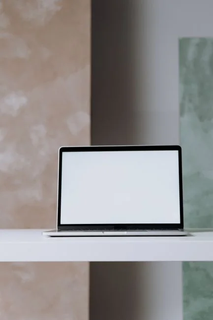 A smartphone in a miniature cart on a laptop symbolizes online shopping and digital payment.